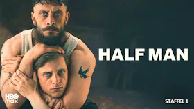 Ein bärtiger Mann im Unterhemd hält den Kopf eines anderen Mannes fest umschlungen. Titel 