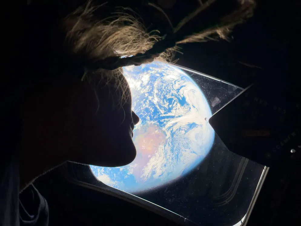 Artemis‑II‑Kommandant Reid Wiseman fotografierte die Erde aus dem Fenster der Orion‑Raumkapsel, kurz nach dem Abschluss des Translunar‑Manövers.. Artemis‑II‑Missionsspezialistin Christina Koch blickt aus einem der Hauptfenster der Orion‑Raumkapsel zurück auf die Erde – während des Flugs zum Mond.
