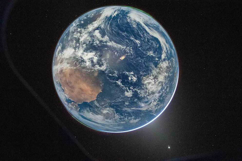 Artemis‑II‑Kommandant Reid Wiseman fotografierte die Erde aus dem Fenster der Orion‑Raumkapsel, kurz nach dem Abschluss des Translunar‑Manövers.