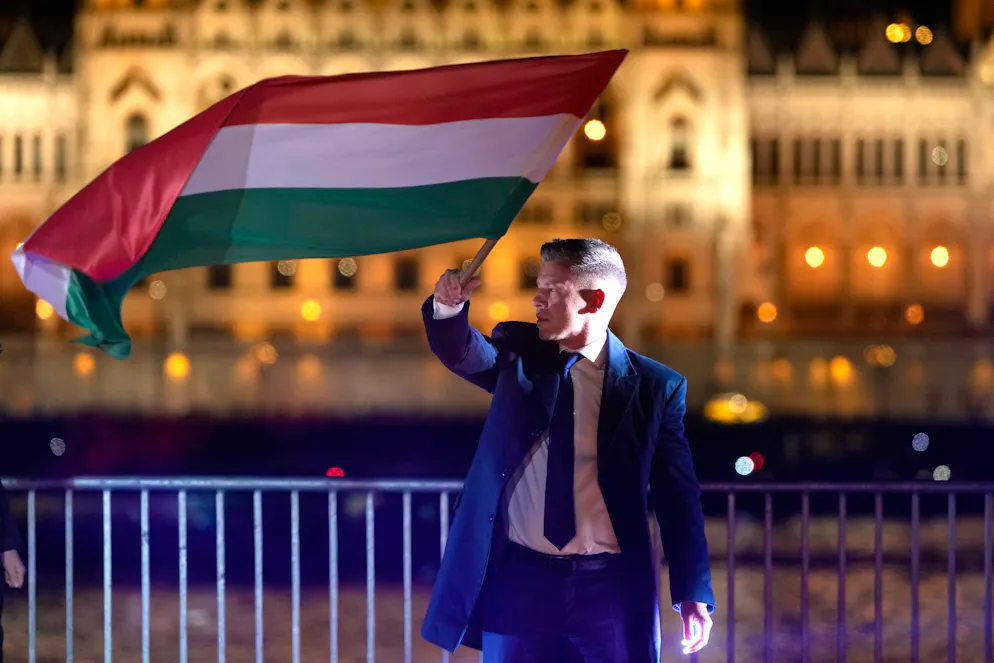 Magyar. Peter Magyar, le chef du parti d'opposition Tisza, brandit un drapeau national après les élections législatives à Budapest, en Hongrie, le dimanche 12 avril 2026. (AP Photo/Darko Bandic)