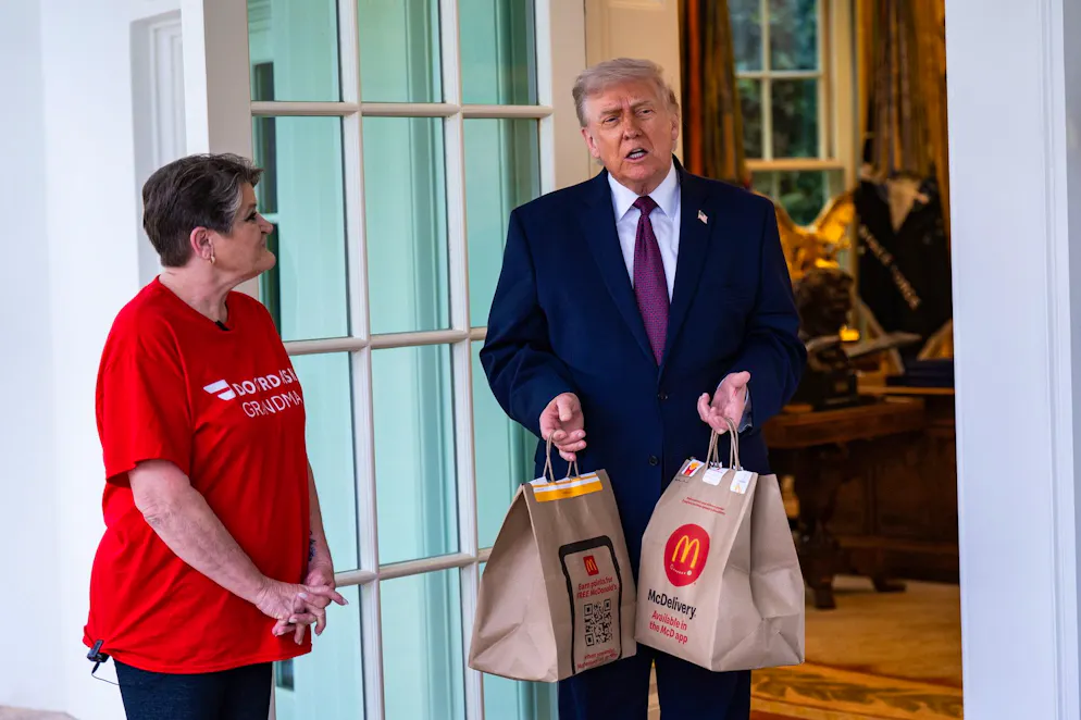 Le président américain Donald Trump reçoit une commande de McDonald's des mains de Sharon Simmons, une livreuse de DoorDash, devant le Bureau ovale de la Maison Blanche à Washington, DC, États-Unis, le 13 avril 2026.