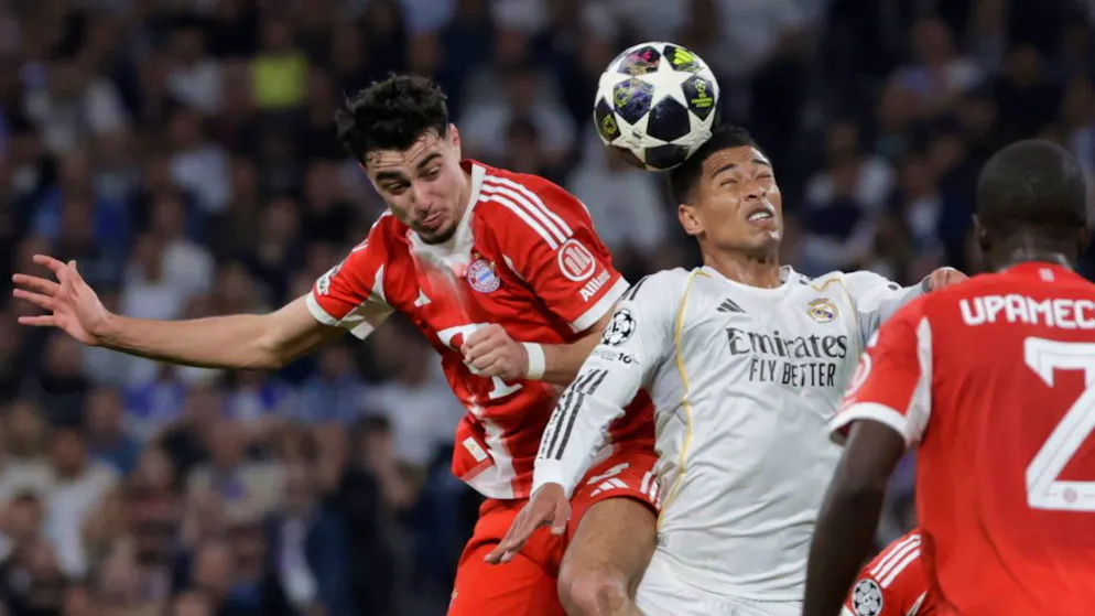 Real Madrids Jude Bellingham (rechts) im Zweikampf mit Bayerns Aleksandar Pavlovic