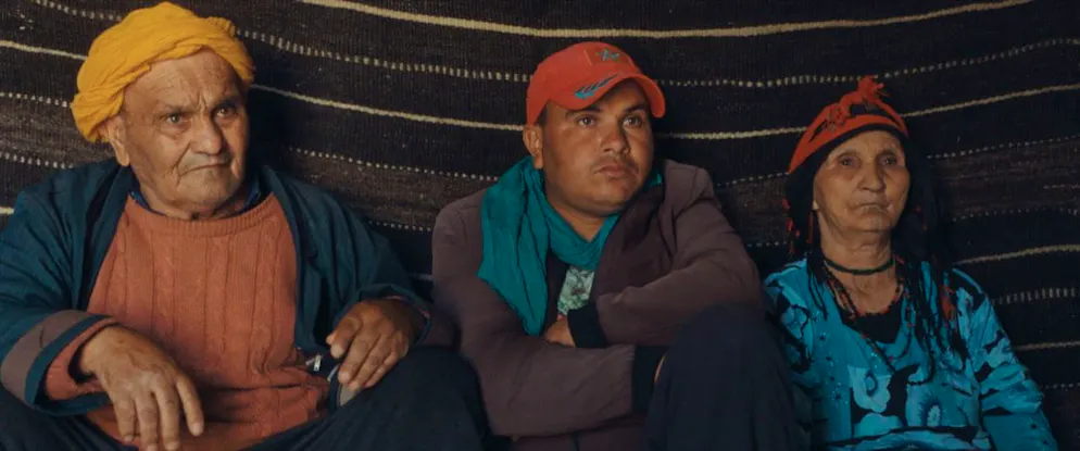 Du soleil et du plomb. La tribu nomade filmée fait partie des Aït Merghrad, l’une des plus anciennes communautés berbères de la région qui vit sur un haut plateau désertique. À l’origine, ils vivaient sur l’autre versant de la chaîne de l’Atlas et ne sont arrivés dans la région qu’à l’époque de la colonisation française — quand il leur a été permis de s’établir à une seule condition : combattre aux côtés des Français contre une autre communauté berbère qui menaçait le site minier que les colons briguaient. Encore aujourd’hui, de nombreux membres de la tribu citent le nom de leurs ancêtres tombés au combat pour la France. Certains attendent même avec impatience l’arrivée des Français (EDF Renouvelable) afin de leur présenter des papiers à leur nom signés à l’époque coloniale. Documents qu’ils considèrent comme la preuve de leur droit à être indemnisés pour cette dépossession.