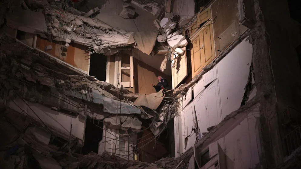 ARCHIV – Eine Frau, die einen israelischen Luftangriff überlebt hat, wartet darauf, aus einem zerstörten Gebäude im Zentrum von Beirut gerettet zu werden. Foto: Emilio Morenatti/AP/dpa