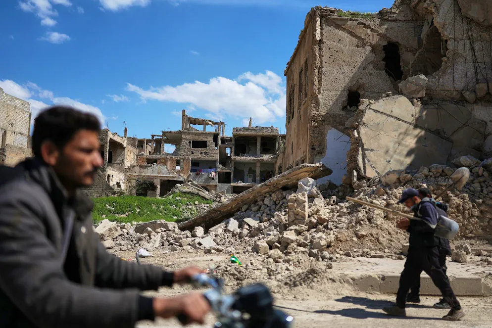 Des habitants passent devant les ruines d’immeubles détruits pendant la guerre à Deir ez-Zor, dans le nord-est de la Syrie, le 11 avril 2026.