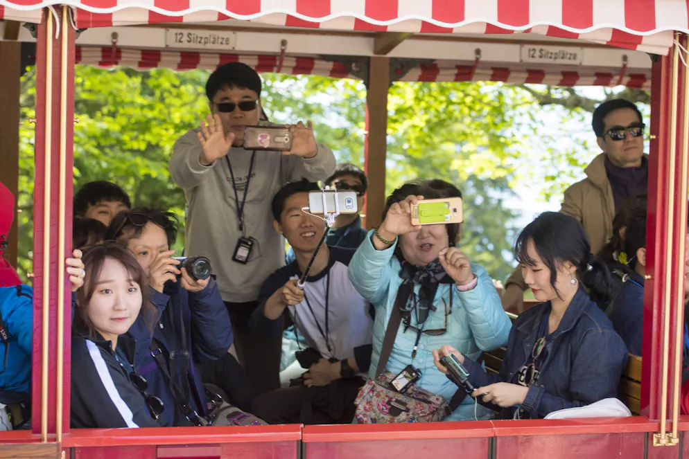 Asiatische Touristen in einem Zug auf der Rigi.