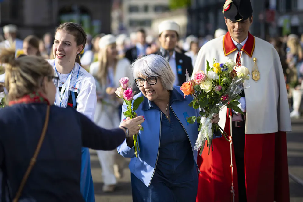 Bundesrätin Elisabeth Baume-Schneider bekommt am Umzug von einer Besucherin Blumen geschenkt.