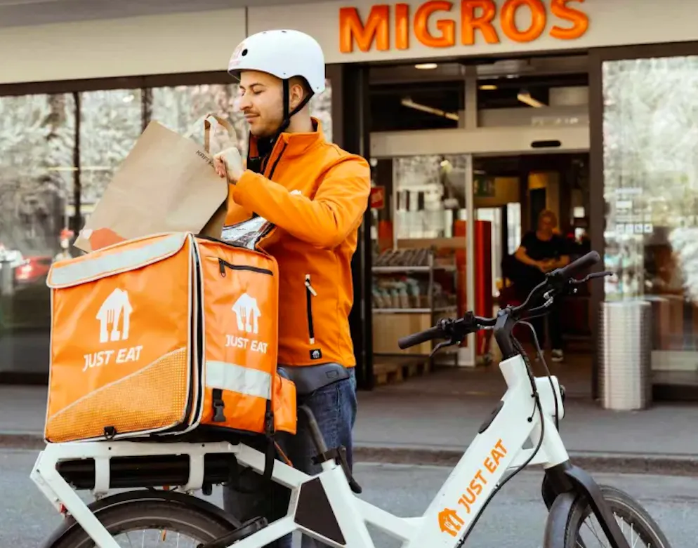 Ab Mai 2026 bringt der Just Eat-Kurier die Migros-Artikel.