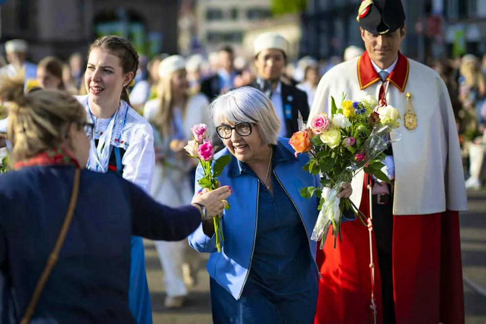 Federal Councillor Elisabeth Baume-Schneider receives flowers from a visitor during the procession.