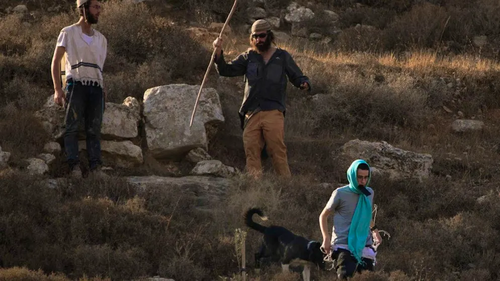 ARCHIVE - Israeli settlers walk down a hill as Israeli soldiers block Palestinian access to an area for olive harvesting in the West Bank village of Sa'ir, near Hebron. Photo: Leo Correa/AP/dpa