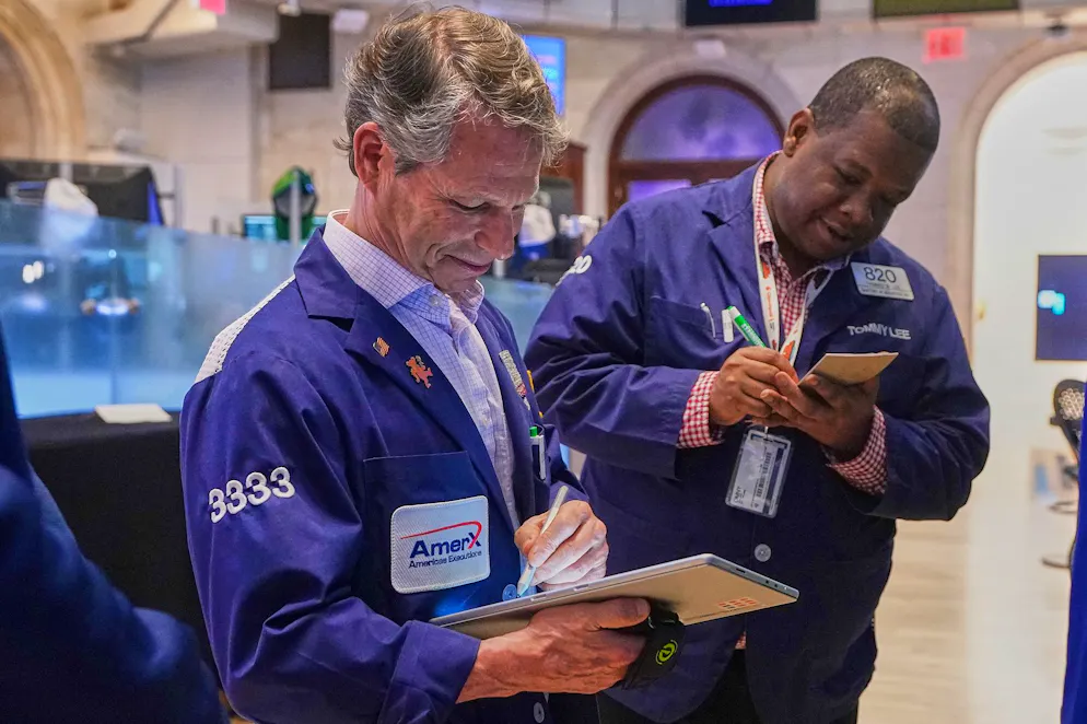 Les courtiers Robert Charmak, à gauche, et Thomas Lee travaillent dans la salle des marchés de la Bourse de New York, le mercredi 22 avril 2026. (Photo AP/Richard Drew)