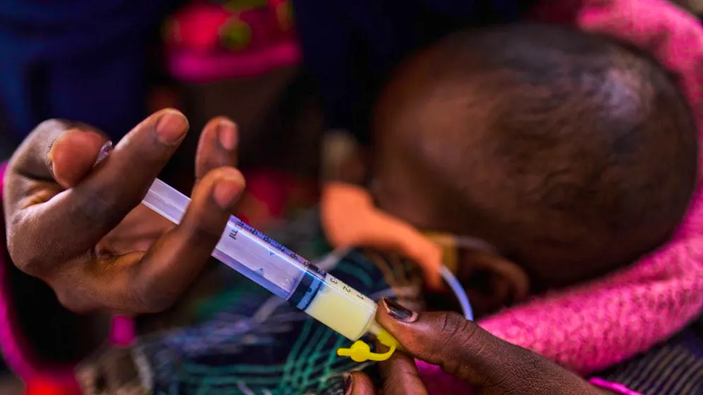 A mother feeds her son, who is being treated for malnutrition, with baby food in the stabilization center of a children's hospital. Photo: Bernat Armangue/AP/dpa