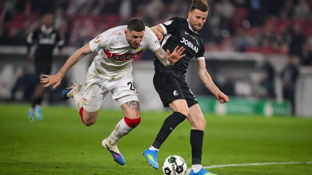 SC Freiburgs Lucas Höler (rechts) begeht in dieser Szene gegen Jeff Chabot nach der Meinung von Schiedsrichter Tobias Welz ein Foul.