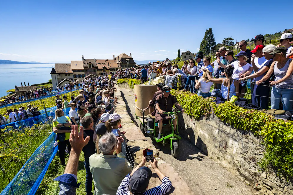 Tracassets. Un tracasset décoré défile sur un chemin entre le vignoble en terrasses de Lavaux devant un public nombreux lors du 24e Championnat du monde de tracassets le samedi 25 avril 2026 à Epesses. (KEYSTONE/Jean-Christophe Bott)