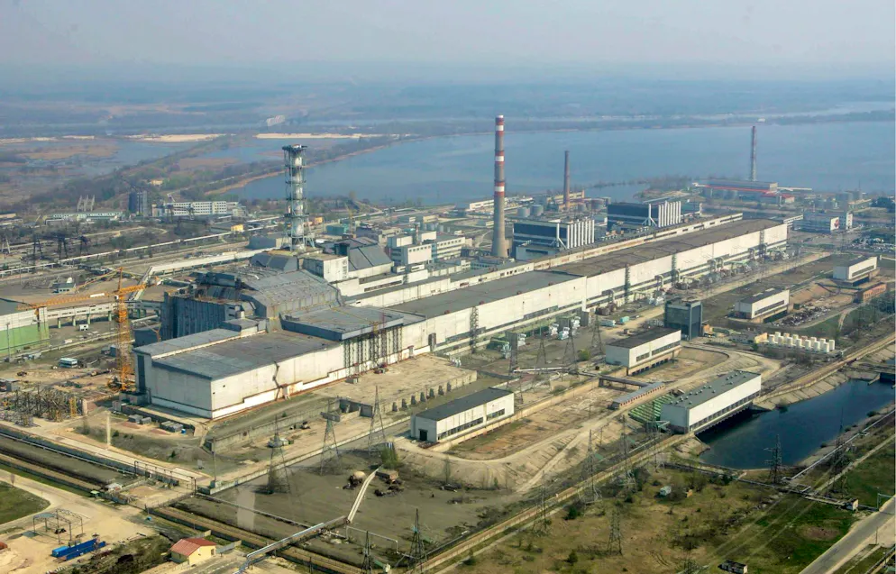 epa03581809 (ARCHIVES) Photo d'archive datée du 26 avril 2006 montrant une vue aérienne de la centrale nucléaire de Tchernobyl. Le toit de la salle des machines de la centrale nucléaire désaffectée de Tchernobyl s'est effondré sous le poids de la neige, a déclaré le ministère ukrainien des Situations d'urgence le 13 février 2013. Le toit ne faisait pas partie du sarcophage en béton recouvrant le réacteur qui a explosé en 1986, mais le bâtiment ne se trouvait qu'à environ 70 mètres de celui-ci. Il n'y a eu aucune fuite radioactive et personne n'a été blessé, a précisé le ministère. EPA/MYKOLA LAZARENKO / POOL