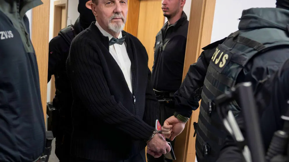 dpatopbilder – Der im Fall des Attentats auf den slowakischen Ministerpräsidenten Robert Fico Angeklagte Juraj Cintula (M) wird mit Handschellen in den Gerichtssaal des Obersten Gerichts der Slowakei geführt. Foto: Martin Baumann/TASR/dpa