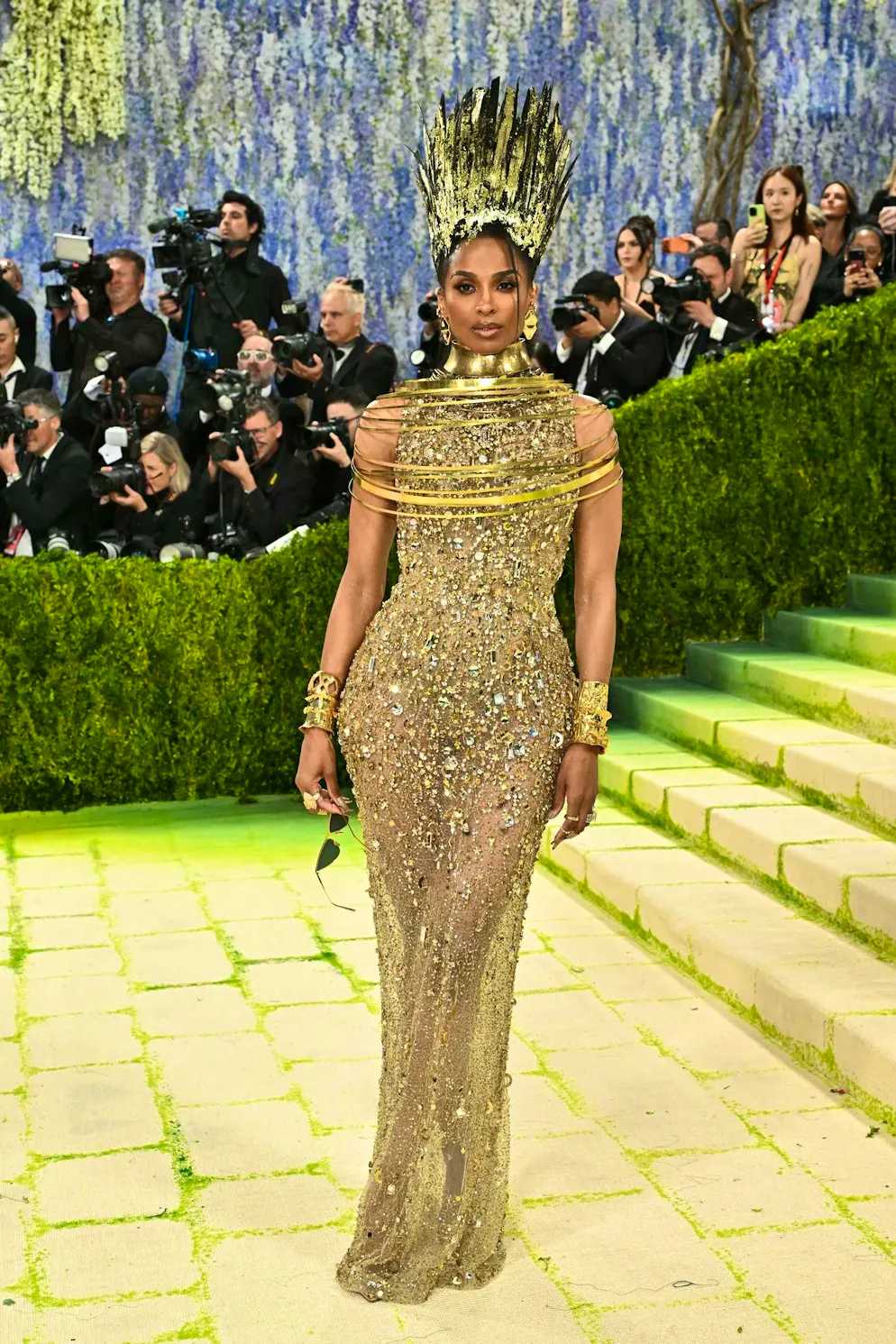 MET Gala - les looks du tapis rouge. Ciara s’inspire de la culture égyptienne et incarne à la perfection le thème « Fashion is Art ». Elle associe à son look doré intégral une coiffe sculpturale impressionnante, véritable pièce statement.