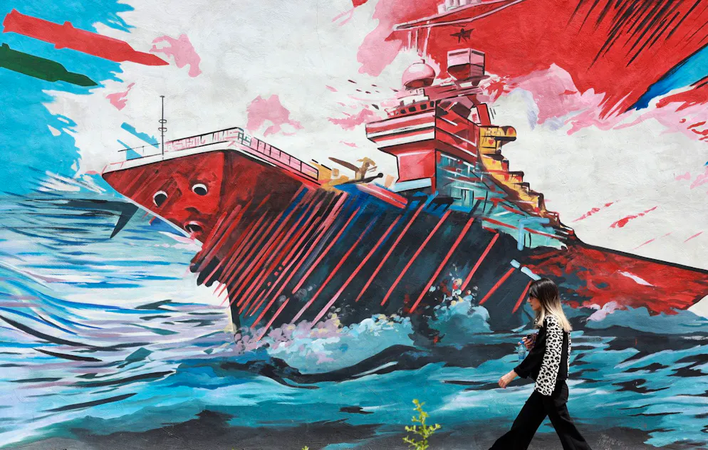 Une personne passe devant une fresque anti-américaine dans une rue de Téhéran, en Iran, le 4 mai 2026. Le porte-parole du ministère iranien des Affaires étrangères, Esmaeil Baghaei, a critiqué les projets du président américain concernant le passage des navires dans le détroit d'Ormuz, au lendemain de l'annonce par Donald Trump que Washington allait commencer à escorter les navires dans cette voie maritime. EPA/ABEDIN TAHERKENAREH