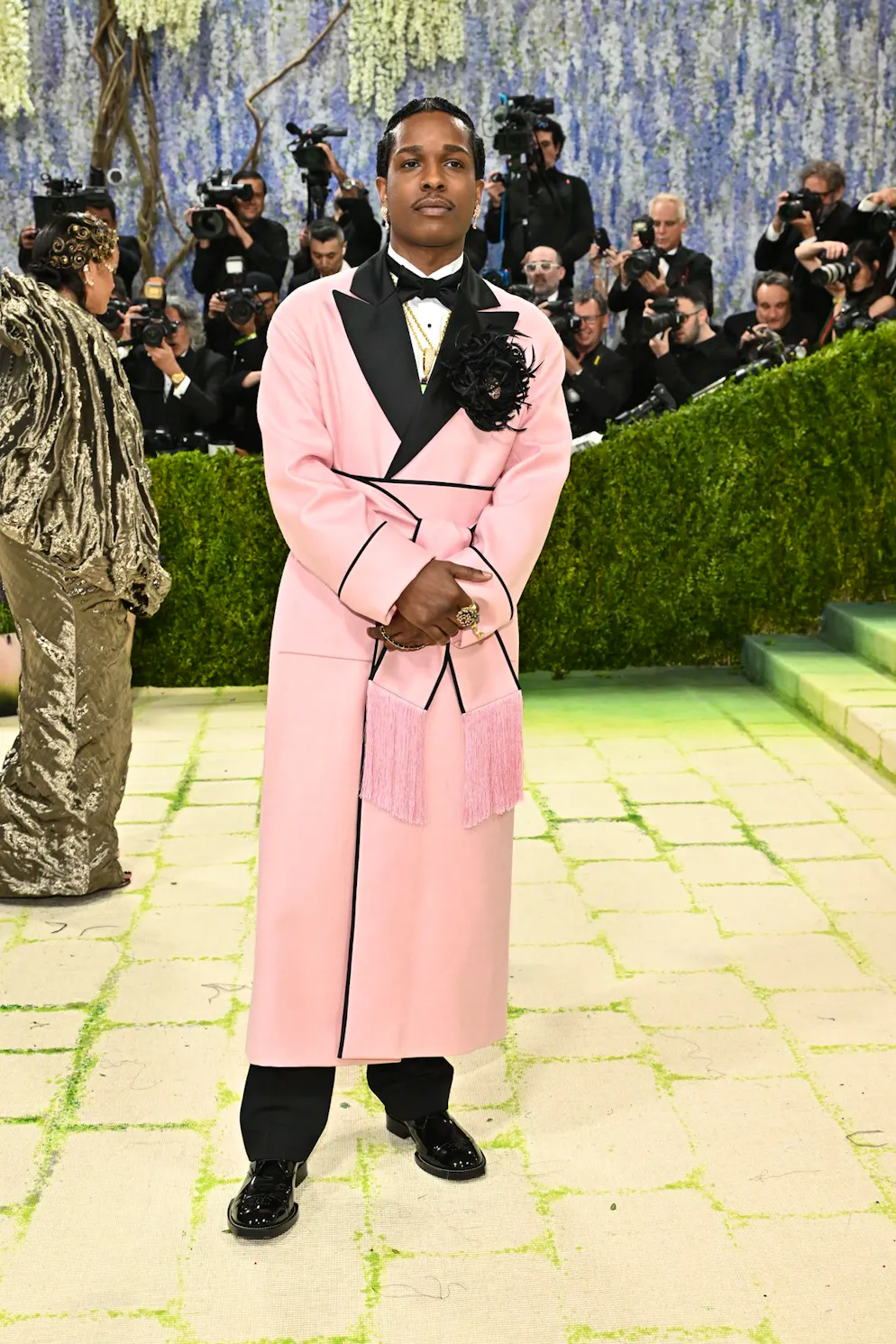 MET Gala – die Looks vom roten Teppich. A$AP Rocky setzt auf Rosa und betont seine Taille mit einem massgeschneiderten Chanel-Look. Federn, Satin und Paspeln dienen dabei als dekorative Elemente und verleihen dem Outfit eine raffinierte Opulenz. Ein Spiel zwischen femininen und maskulinen Codes, bewusst subtil und dennoch wirkungsvoll inszeniert.