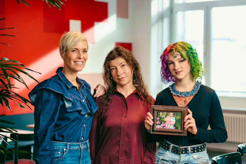 Mère et fille aux côtés de l'ambassadrice de la Croix-Rouge suisse, Mélanie Freymond. Sacha, 20 ans, tient une photo de sa grand-mère Lydia.