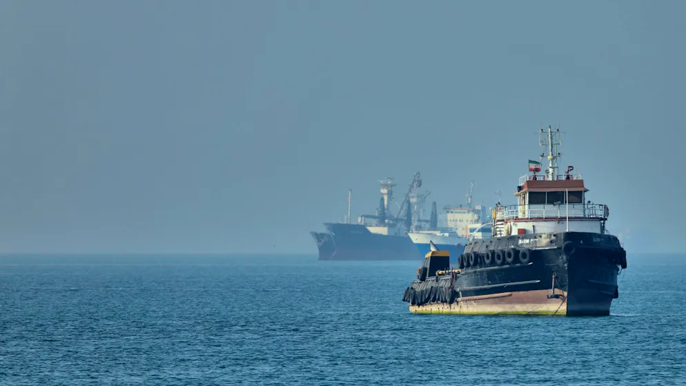 Ein iranischer Schlepper in der Strasse von Hormus, dahinter Frachtschiffe vor Anker. (4. Mai 2026)