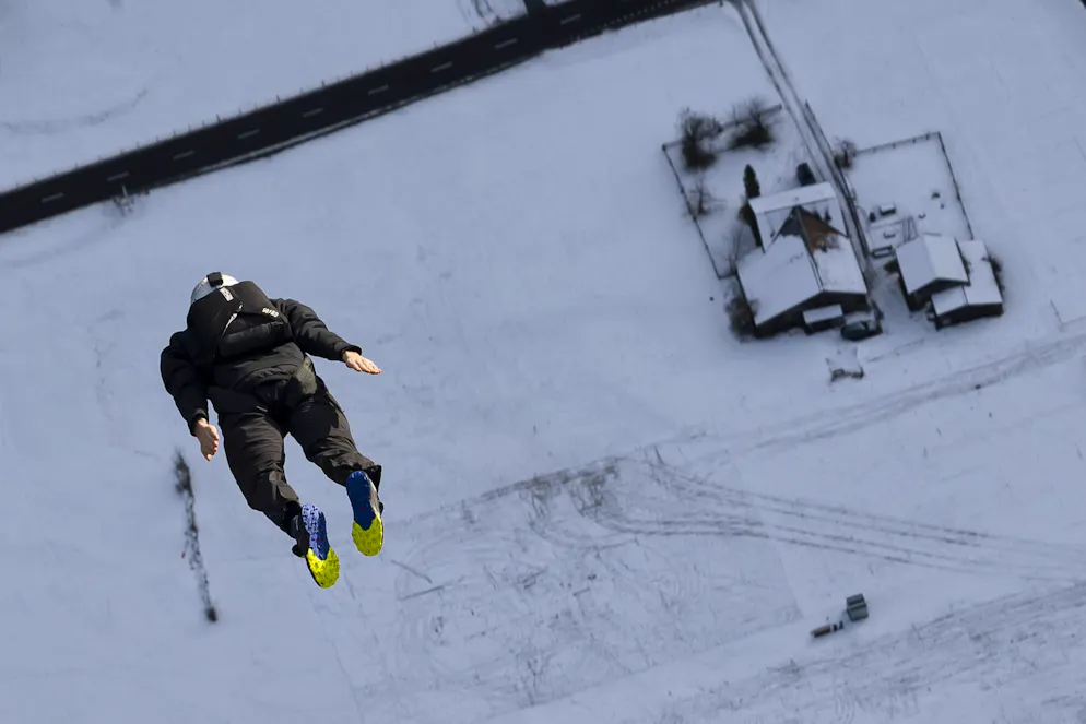 A base jumper flies to the valley, below Muerren, in the Lauterbrunner region of the Bernese Oberland, Switzerland, on December 17, 2024. (KEYSTONE/Anthony Anex)
