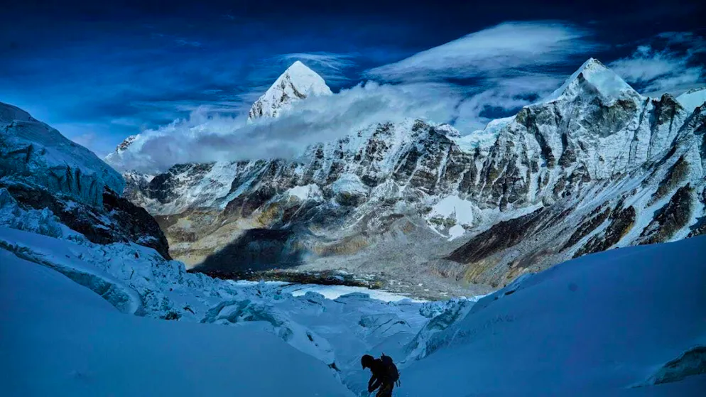ARCHIVE - Mount Pumori (center l) looms in the background as a climber crosses the Khumbu Icefall to descend to Everest Base Camp. Photo: Pasang Rinzee Sherpa/AP/dpa (archive photo)