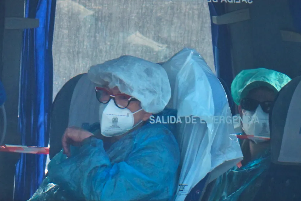 Die evakuierten Menschen trugen Schutzanzüge und Masken.