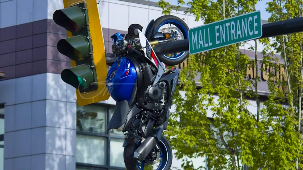Incidente surreale in Canada. Dopo uno scontro con un'auto, la moto finisce appesa a un semaforo