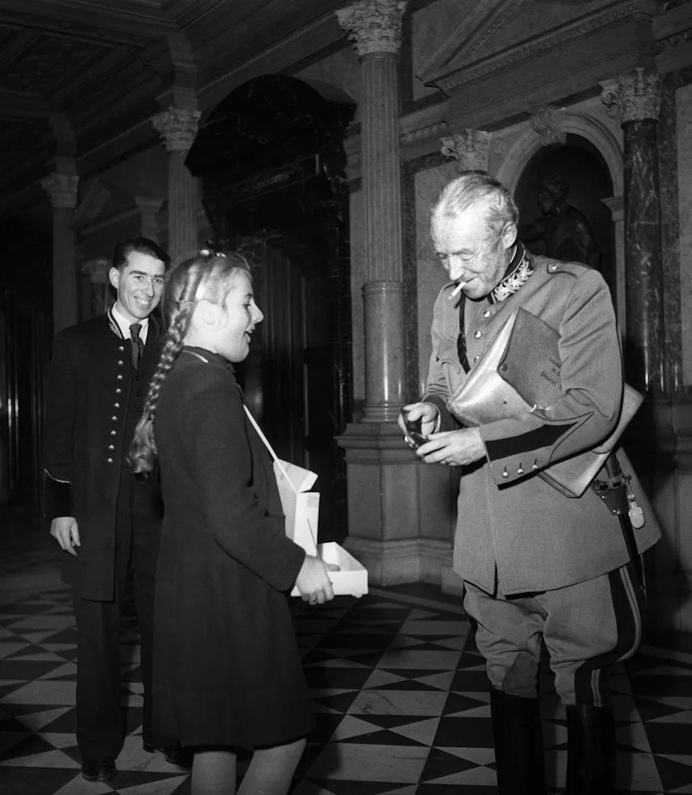 Die Story des Schweizer Schoggitalers. General Henri Guisan kauft einer Schülerin in der Eingangshalle des Bundeshauses einen Schoggitaler zum Schutz des Silsersees ab, der ersten Aktion dieser Art des Schweizer Heimatschutzes und Pro Natura, aufgenommen am 8. Februar 1946. 