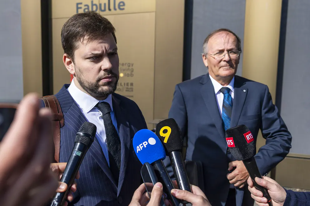 Bryan Pitteloud, à gauche, avocat, et Jean-Claude Savoy, à droite, ancien président de la commune de Chermignon, s'adressent aux journalistes lors d'une conférence de presse organisée par le ministère public du canton du Valais, à la suite de l'incendie meurtrier survenu au bar « Le Constellation », à Sion, en Suisse, le mercredi 13 mai 2026.
