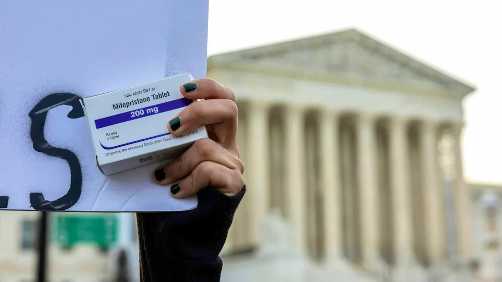 An anti-abortion activist holds up a pack of Mifepristone during a protest outside the Supreme Court in Washington. (stock image)