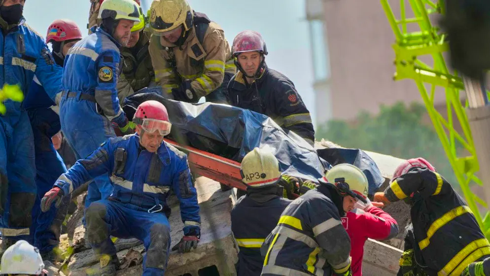 Rescue workers carry the body of a resident who was killed when a Russian missile hit a residential building during a massive airstrike. Photo: Efrem Lukatsky/AP/dpa