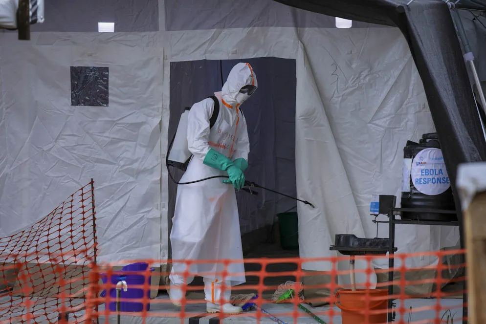 FILE - A medical worker disinfects a tent used for suspected Ebola victims inside the Ebola isolation center of Madudu Health Center III, in the village of Madudu, in the Mubende district of Uganda Tuesday, Nov. 1, 2022. The head of the World Health Organization said Wednesday, Nov 16., 2022, that he expects the first doses of Ebola vaccine targeting the strain causing the current outbreak in Uganda to arrive in the country next week. (AP Photo/Hajarah Nalwadda, File)