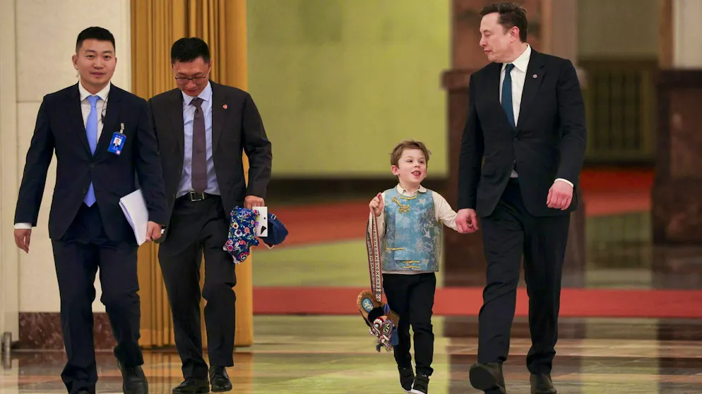 Tesla and SpaceX CEO Elon Musk (right) with his son X Æ A-12 and his Tiger bag in Beijing on Thursday.