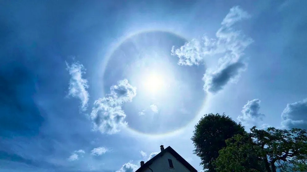 Il fenomeno dell'alone di 22 intorno al Sole è fotografato nel cielo blu di Porrentruy domenica.