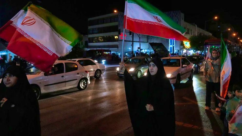 ARCHIVE - Women hold Iranian flags at a pro-government rally in downtown Tehran. Photo: Vahid Salemi/AP/dpa
