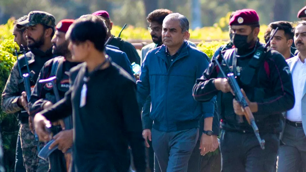 ARCHIVE - Security officials escort Pakistani Interior Minister Mohsin Naqvi (center) as he arrives to talk to the media about the current situation regarding the clashes at D-Chowk Square near the Red Zone. Photo: W.K. Yousufzai/AP/dpa (archive picture)