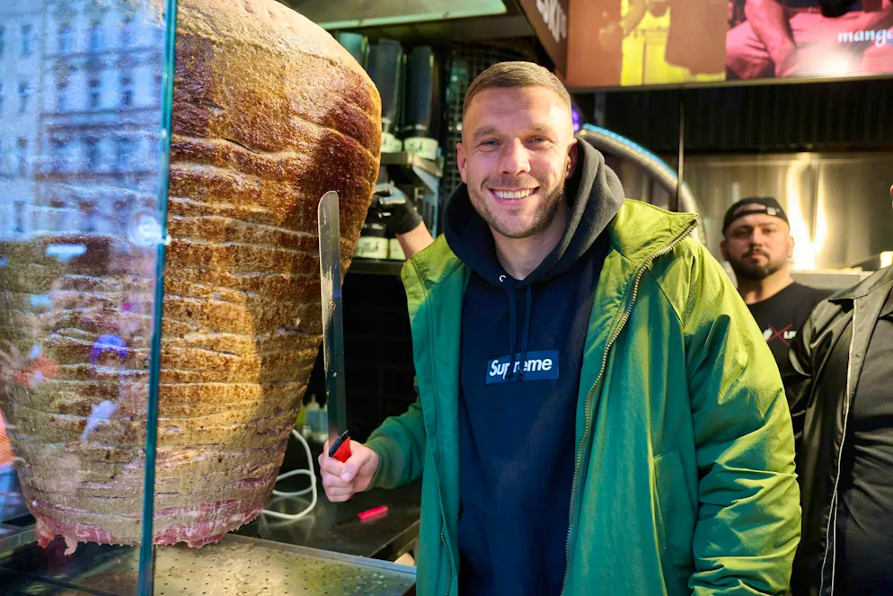 Lukas Podolski stands at a spit during the opening of Podolski's kebab snack bar in March 2024.