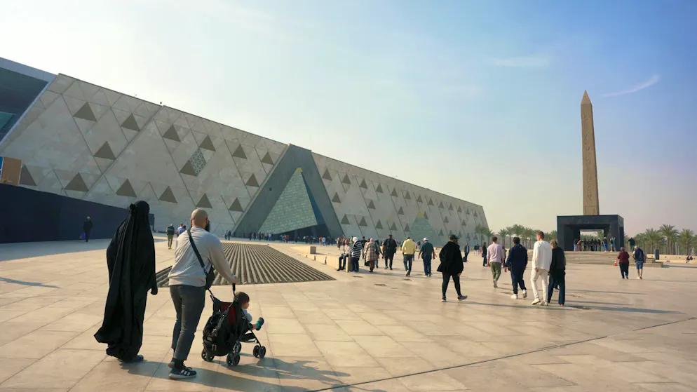 The impressive backdrop of the Grand Egyptian Museum (GEM) in Giza is dominated by the monumental façade and the hanging obelisk of Ramses II enthroned in front of it.