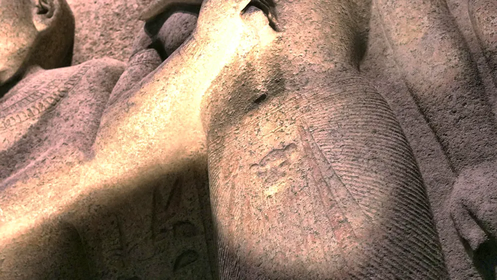 Egyptian sculptures - including this group of statues - were originally almost completely painted. The remains of paint visible today on the skirt of the middle figure confirm this practice.