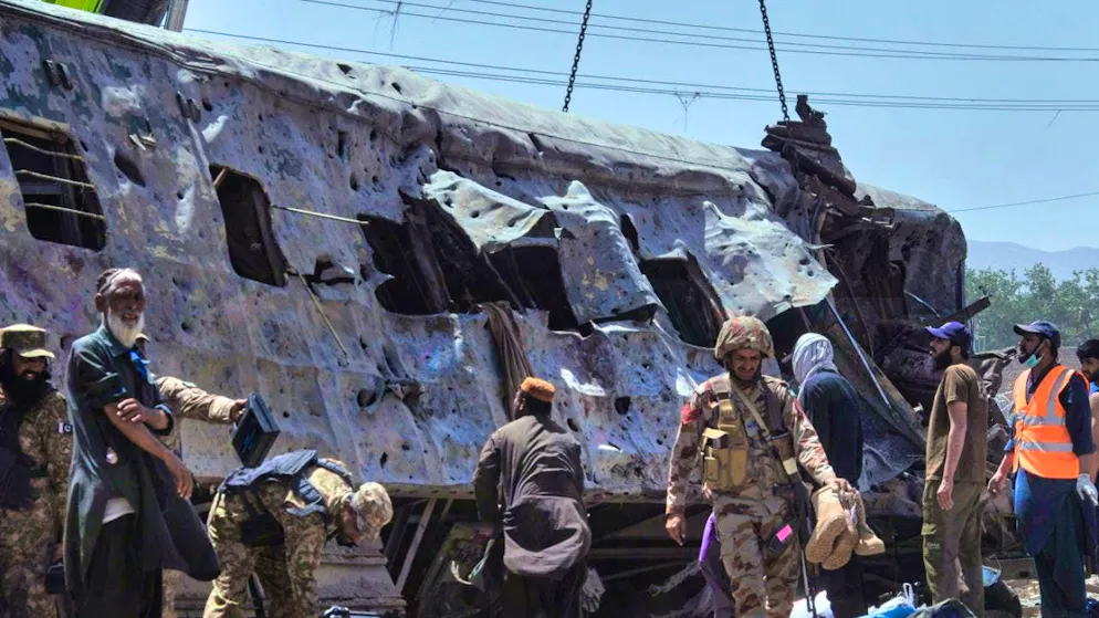 Security officials inspect a damaged train carriage on a railroad track at the site of a bomb blast in Quetta.