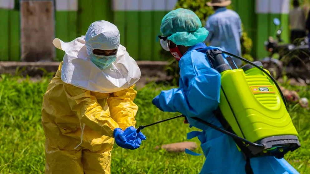 ARCHIVE - Red Cross staff disinfect themselves. Photo: Moses Sawasawa/AP/dpa