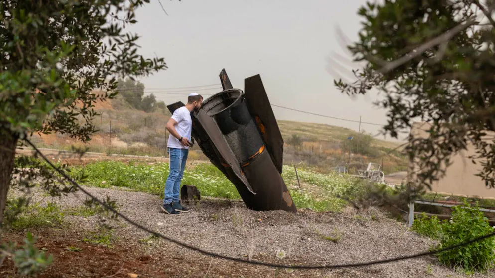 ARCHIV – Ein israelischer Mann betrachtet in der jüdischen Siedlung im nördlichen Jordantal das Heckteil einer vom Iran abgeschossenen ballistischen Rakete. Foto: Oren Ziv/dpa