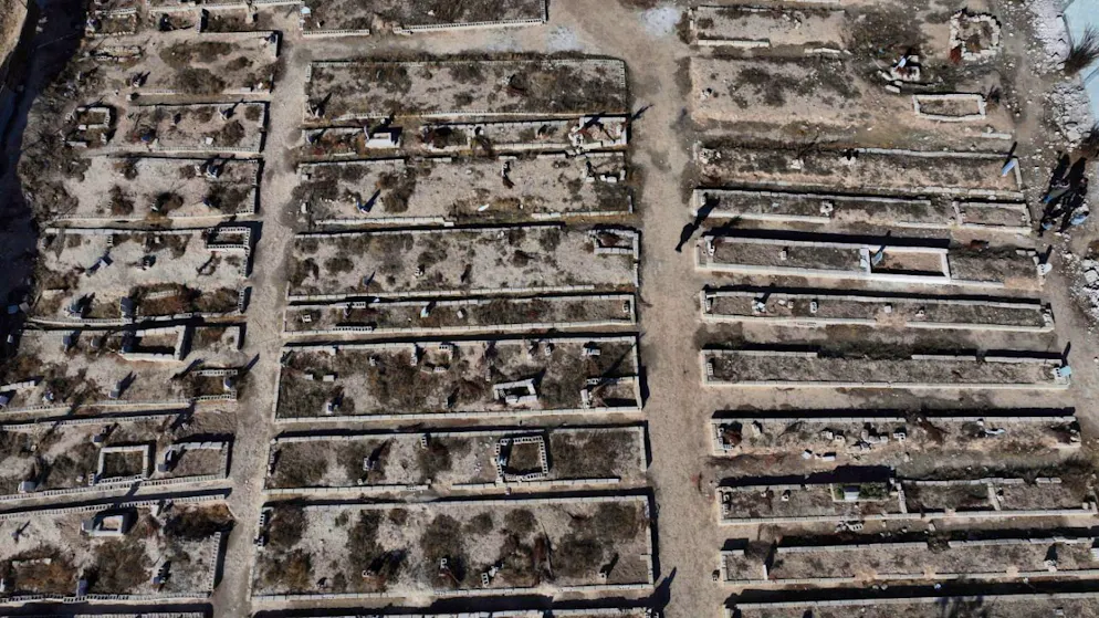 ARCHIV – Eine Luftaufnahme zeigt ein Massengrab in Syrien, in dem Menschen begraben sind, die bei einem Chemiewaffenangriff durch Sarin getötet wurden. Foto: Hussein Malla/AP/dpa/Archivbild