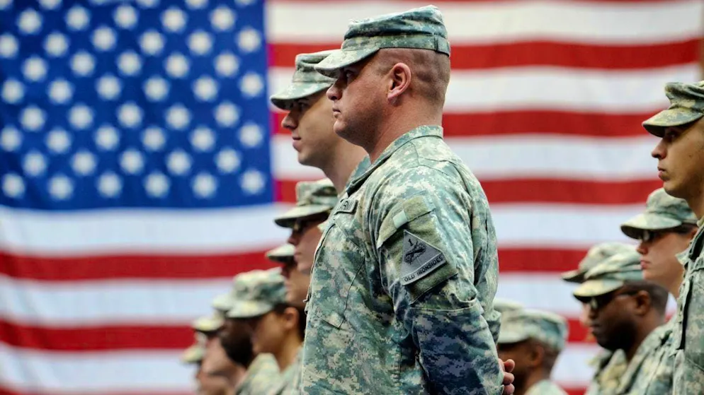 ARCHIVE - US soldiers stand in front of a US flag after their arrival at the US airbase in Wiesbaden-Erbenheim. Photo: Frank May/dpa (archive photo)