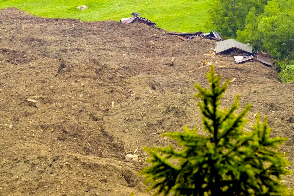 Une immense avalanche composée d'un mélange de glace, de roches, de neige et d'eau a atteint le fond de la vallée à Wiler, suite à l'effondrement du glacier de Birch au-dessus de Blatten, en Suisse, le mercredi 28 mai 2025. (KEYSTONE/Jean-Christophe Bott)