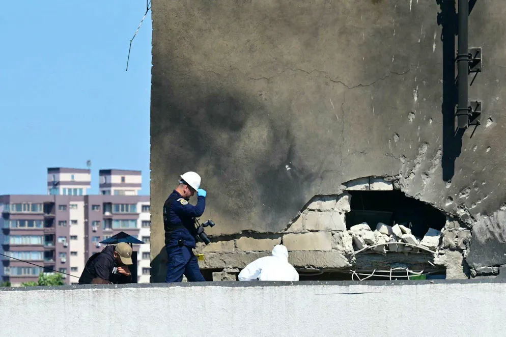 Police and forensic investigators examine the location of impact after a Russian drone struck an apartment building in Galati, eastern Romania. A Russian drone wounded two people as it struck an apartment building in NATO-member Romania, its defence ministry said on May 29, 2026, the latest spillover from the four-year war into neighbouring states. (Photo by Daniel MIHAILESCU / AFP)