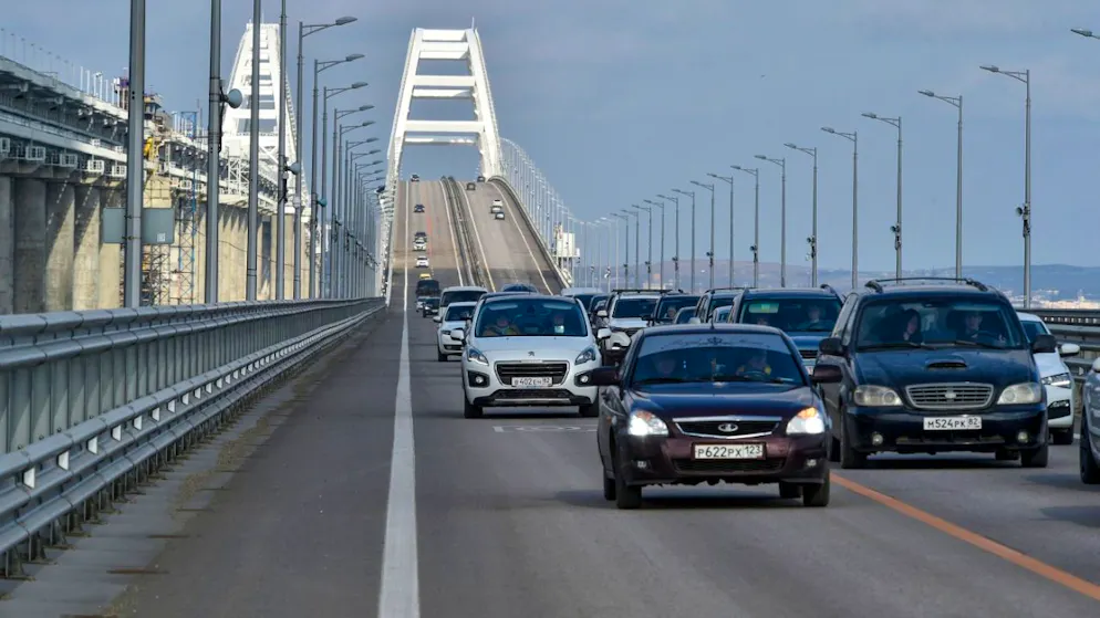 ARCHIV – Autos und andere Fahrzeuge fahren auf der Krim-Brücke, die das russische Festland und die Halbinsel Krim über die Meerenge von Kertsch nach Restaurierungsarbeiten wieder verbindet. Foto: Uncredited/AP/dpa