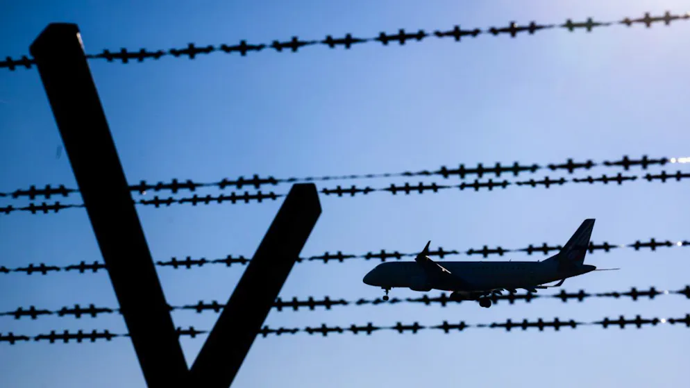 ARCHIV – Ein Flugzeug mit abgeschobenen Migranten fliegt hinter Stacheldraht am Flughafen Hannover. Foto: Julian Stratenschulte/dpa/Symbolbild